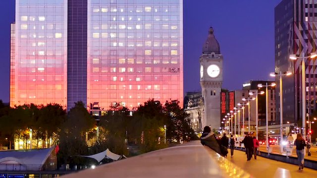 View of the Gare de Lyon and the clock tower in Paris. Filmed during the fall of the night, colors of the sunset that is reflected on the glass buildings.