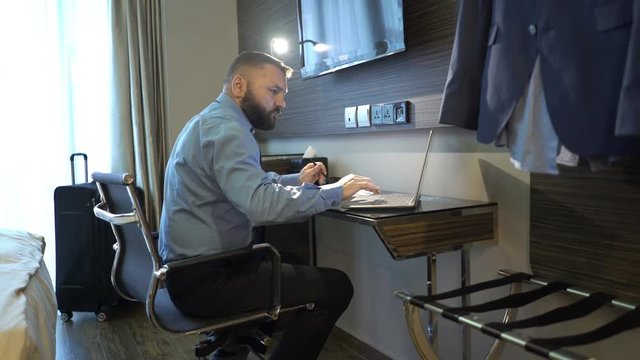 Businessman working with laptop computer and documents at hotel