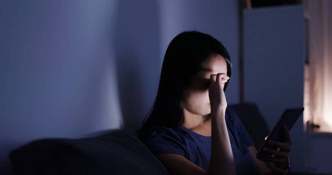 Woman use of cellphone and feeling eye pain at night
