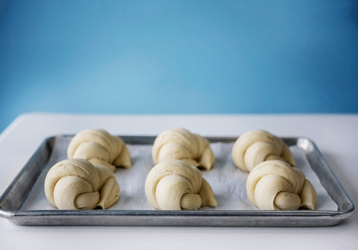 Croissant dough rises on a sheet pan.