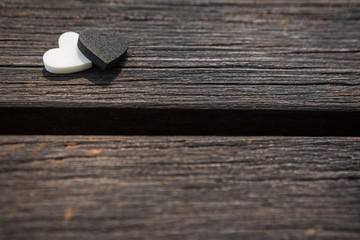 Little white and black heart on an old wooden table
