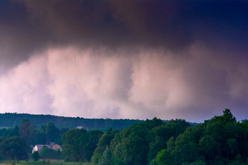 Thunderclouds against the clear evening sky. Dramatic condition in nature. Summer time in Ukraine.