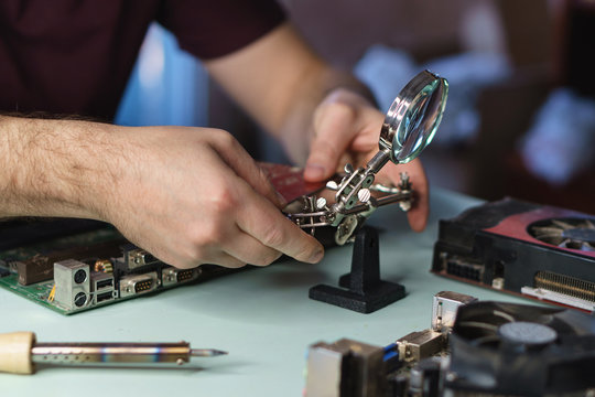 Repair motherboard. Man repairing motherboard. Working process and working professional table. Close-ups