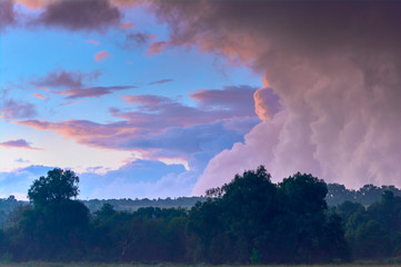 Thunderclouds against the clear evening sky. Dramatic condition in nature. Summer time in Ukraine.