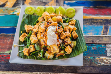 Gado-gado Indonesian salad served with peanut sauce. Ingredients: tofu, spinach, string beans, soy...