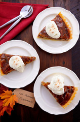 Traditional Thanksgiving Pecan Pie individual slices on plates overhead with We Gather Together place card on vintage dark wood table setting. 