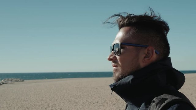 Handsome man with sunglasses in the Middle of the desert student tourist wind
