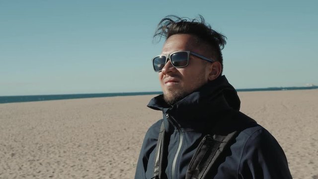 Handsome man with sunglasses in the Middle of the desert student tourist wind