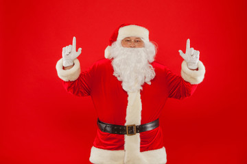 Santa Claus pointing in blank a place, red background.