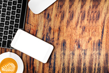Wood office table with computer keyboard, mouse, smartphone, hot coffee.