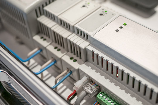 Network switches and ethernet LAN cables connected to smart house equipment, modern technology concept