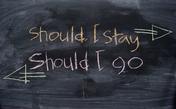 Should I stay or Should I go written with color chalk concept on the blackboard