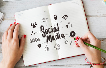 Young woman drawing social media in a notebook