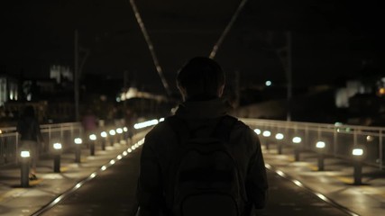 Rear view at a lonely man in hood, standing his back outside, walking down empty street, homeless abandoned hooded troubled guy wandering big city at night - Powered by Adobe