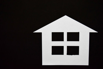Concept of house in paper on black background. Horizontal composition. Top view.