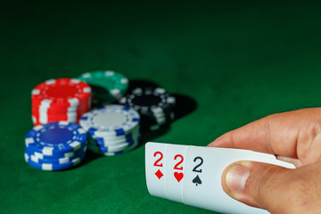 Casino games concept,Poker chips on gamble table , Light through background, winning hands of cards. gambling success