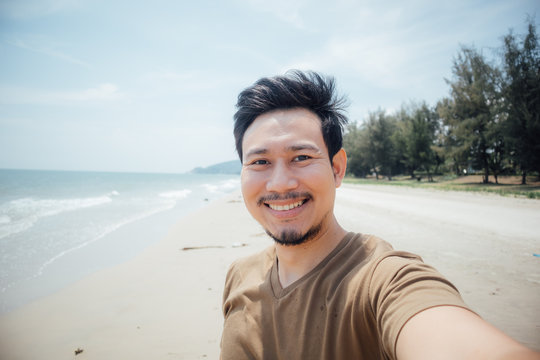 Cheerful and happy face of man selfie himself on the beach.