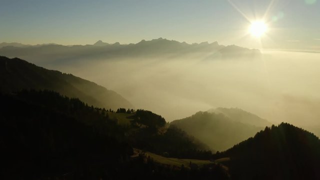 Flying high above mist layer at sunset in alpine environment. Near "Les Rochers de Naye", Switzerland