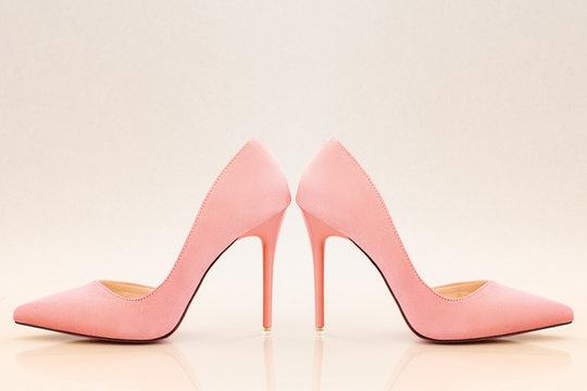 Soft pink suede high heels on light background
