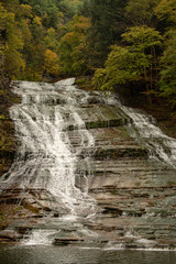 Obraz premium Waterfall cascading over the rocks in Buttermilk falls state park, New York
