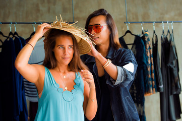 young beautiful and happy woman enjoying shopping trying out clothes and vintage hat looking at mirror in beauty fashion store smiling cheerful having fun