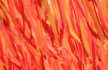 Background of many orange decorations ribbons hanging for festival.