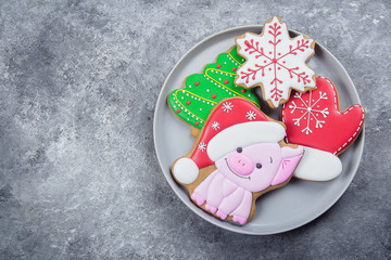 Happy New Year and Merry Christmas gingerbread on plate on gray stone background. Symbol of year 2019 - pig and other various cookies. Top view, copy space