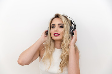 Portrait of a young woman singer with headphones. Listening to music.