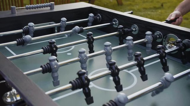 People playing babyfoot outside in slow motion