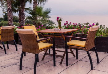 A cozy cafe on the terrace in the restaurant, overlooking the sea and tropical plants. Service for holidays and weekends. Vacation at the sea and dinner at the restaurant.