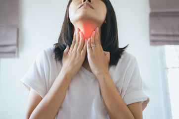 Asian woman have a sore throat,Female touching neck with hand,Healthcare Concepts