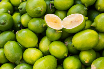 Green fresh juicy lime is on the layout in the store, sold on the market. Ingredient for refreshing cocktails and alcoholic drinks, and juice. Sliced fruit slices