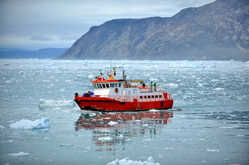 Red ship in the sea among the ice