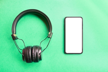 Headphones and smartphone on colorful background.