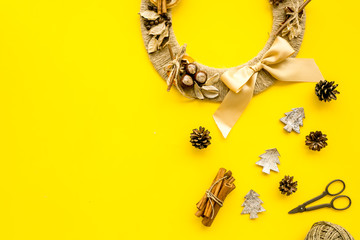 Preparing to Christmas. Creative christmas wreath made of thread near decorative elements on yellow background top view copy space