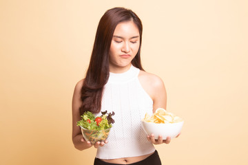 Young Asian woman with potato chips and salad.