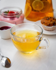 cup of tea with lemon, jam, muffin