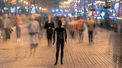The dummy standing on the evening street with people
