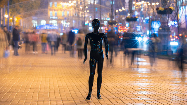 The mannequin standing on the crowd street. evening time