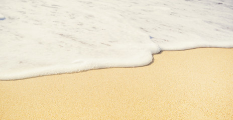 Water edge and sand. Close-up summer beach background. Vacation and traveling concept.