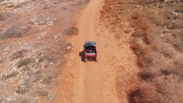 Aerial tracking shot following ATV driving on the Cavo Greko dirt trails - Powered by Adobe