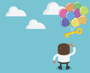 African businessman looking at a key that is drifting up from the sky. .It's like a success that fades away.