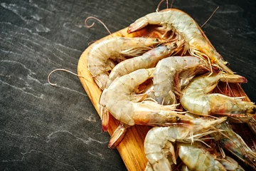 Fototapete Rund fresh delicious raw tiger prawns on a wooden board on a black wooden table © superelaks