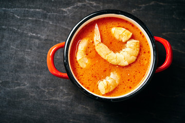 traditional Thai soup with shrimp and coconut milk in a red pot