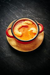 traditional Thai soup with shrimp and coconut milk in a red pot