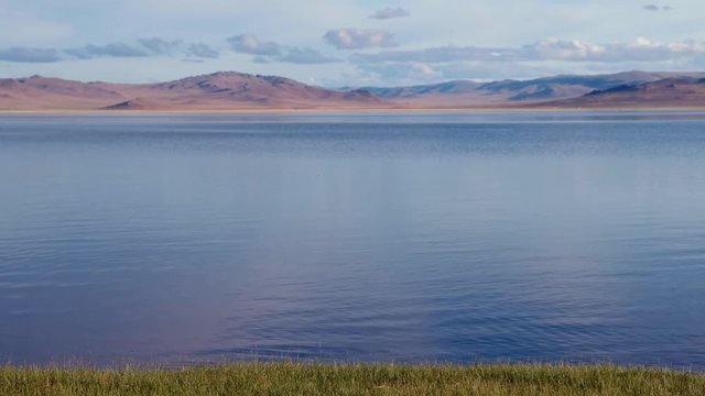 Calm waters of mongolian lake Telmen Lake surrounded by hills and deserts in north Mongolia