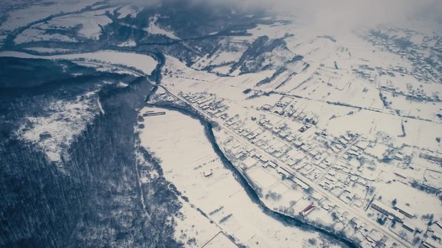 Aerial shot: Mountain village in fog from bird eae view