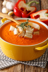 Dietary cream soup with sweet pepper and croutons close-up. vertical
