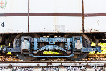 Railroad wagon wheel pair on a rail with big laminated leaf spring and spiral spring - closeup