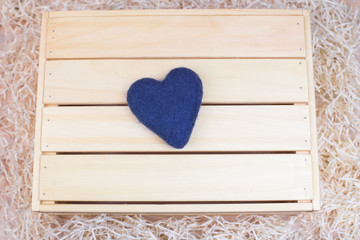 Wooden background with a heart made of wool